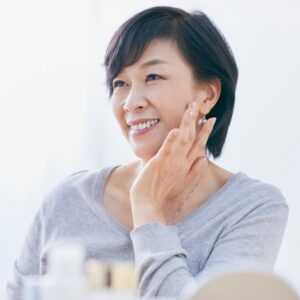 older woman touching her face and smiling